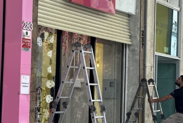 Porta de aço com a fita rasgada, e uma escada em baixo onde um especialista deixou para fazer o reparo