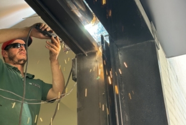 Especialista fazendo a soldagem em uma porta de aço manual